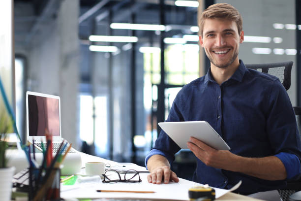 istock Young modern business man working using digital tablet while sitting in the office. 1466263125