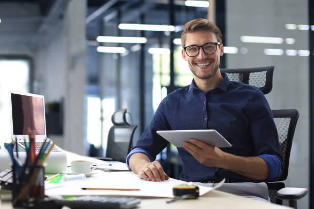 istock Young modern business man working using digital tablet while sitting in the office. 1466263395