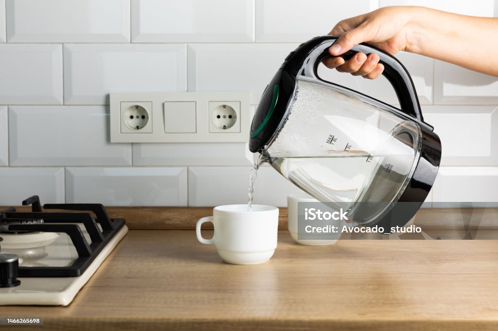 https://media.istockphoto.com/id/1466265698/photo/a-man-makes-tea-using-boiling-water-from-an-electric-kettle-in-the-kitchen-at-home-its-time.jpg?s=1024x1024&w=is&k=20&c=GUqz4wwo9FH2YIrbdrRsGUtSM6hFj0m5mLQdPim38Pg=