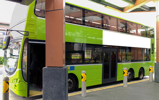 Mock up for double decker bus wrap poster advertising. Vehicle waiting at bus stop; no people