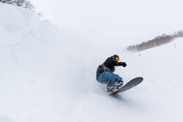Snowboarder riding the famous powder snow of North Japan A freestyle snowboarder riding in Shizukuishi, Iwate. Famous powder of North Japan. japanese snowboarder stock pictures, royalty-free photos & images