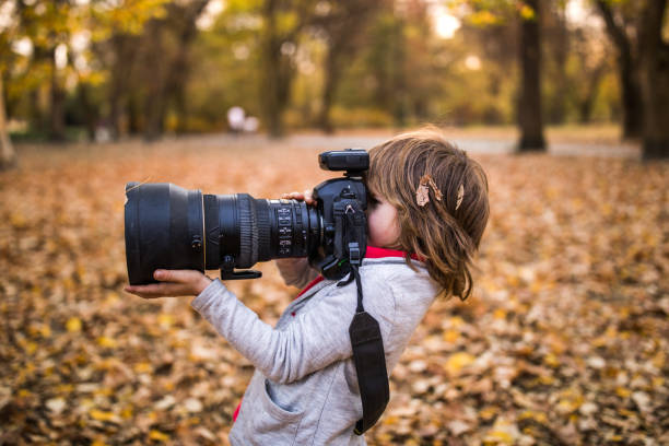 istock Small boy using DSLR camera in autumn day at the park. 1466274834