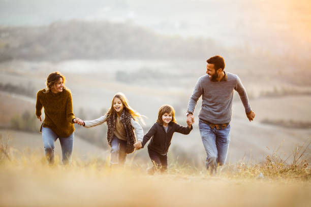 istock Playful family having fun while running in autumn day on a hill. 1466276809