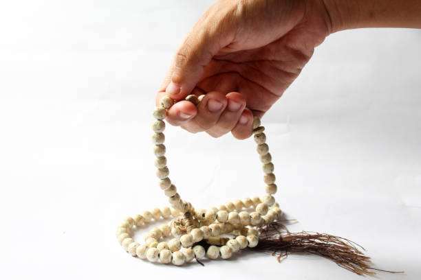 istock someone's hand holding a prayer beads 1466285004