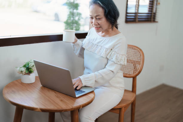 istock Portrait of an elderly Asian woman in a modern pose working on a computer. 1466290620