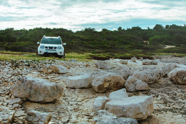 istock white suv between rocks. off road car travel concept 1466291847