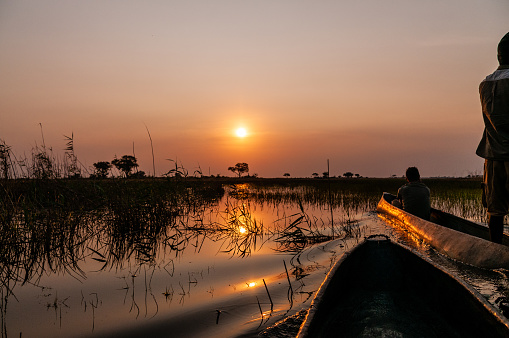 Okavango Delta, Botswana - August 3, 2022. A first person perspective of a sunset in the Okavango delta, as observed from a mokoro.
