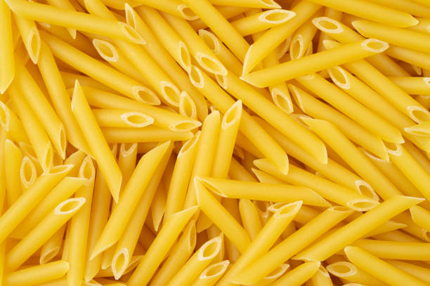 sfondo pennettino di pasta italiana. vista dall'alto, primo piano. - italian cuisine dry pasta directly above foto e immagini stock