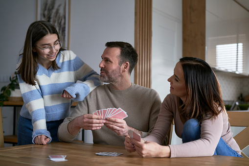 Caucasian happy family playing in card at home