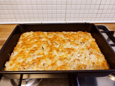 Baked cauliflower and grated cheese dish in oven at glasgow scotland england uk