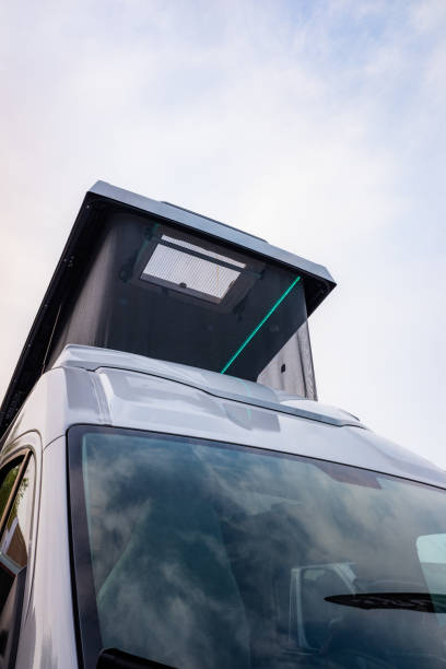 istock Contemporary camping van with a rooftop tent under the cloudy blue sky 1466306277