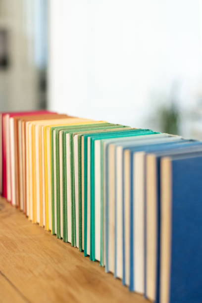 istock Vertical shot of stacked colorful books on different fields on the table with a blurry background 1466306646