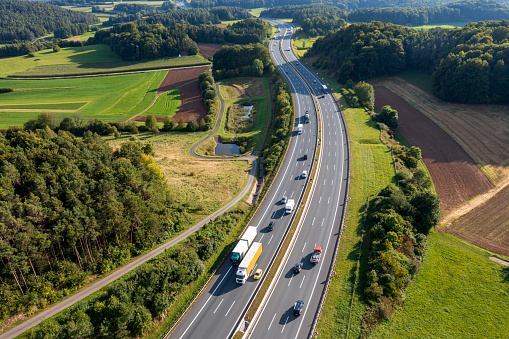 Aerial view of multiple lane rural highway with truck and car traffic.