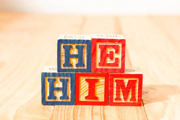 Spectacular wooden cubes with the word HE HIM on a wooden surface