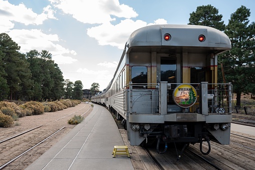 Grand Canyon, United States – August 18, 2022: A classic Grand Canyon train at the station with vegetation in the background