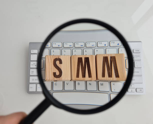 istock SMM abbreviation from wooden cubes on computer keyboard and magnifier 1466308905