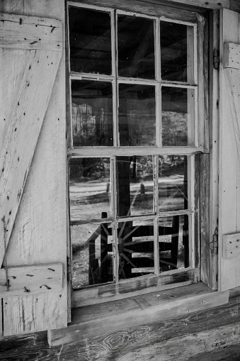 A closeup of windowpanes and shutters from civil war era 1800slog cabin in Callaway gardens in Georgia