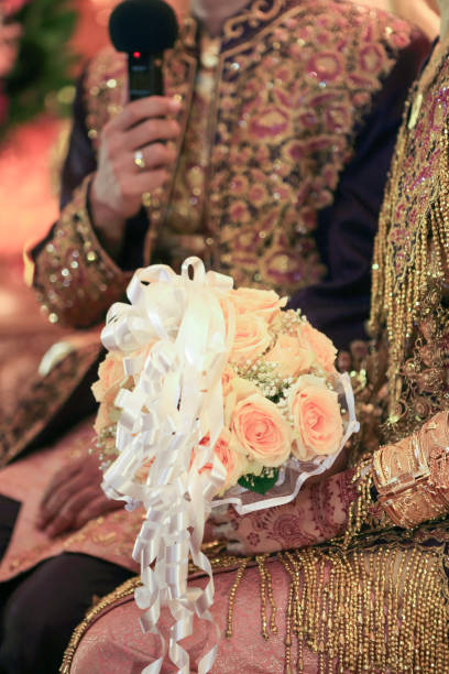istock Groom and bride hands holding flower bouquet 1466311589
