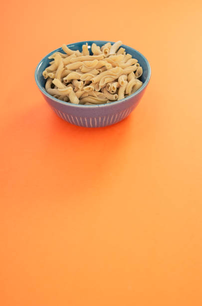istock Bowl of cooked pasta on orange background with copy space at the bottom 1466316083