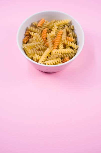 istock Top view of little white pottery with colored pasta isolated on 1466316940