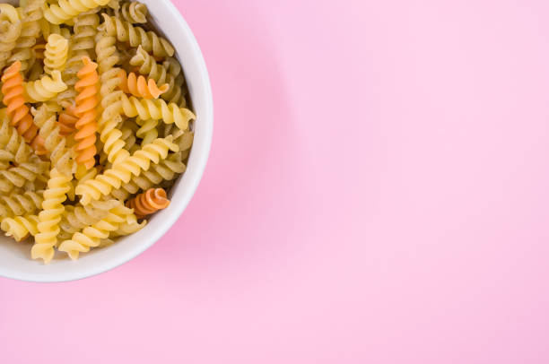 istock Top view of little white pottery with colored pasta isolated on 1466316944