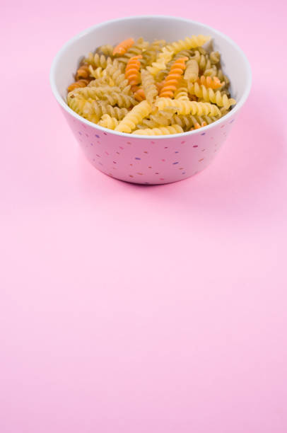 istock Top view of little white pottery with colored pasta isolated on 1466316945