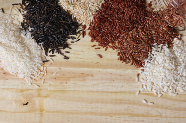 vue de dessus des types de riz noir sauvage, brun, jasmin, arboricole et rouge himalayen sur une table en bois - rice black wild rice dry photos et images de collection
