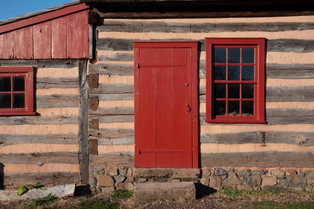 istock Colonial log cabin exterior with red window and door 1466318249