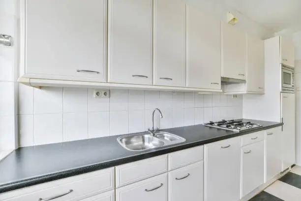 A kitchen with white new furniture