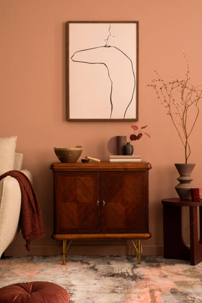 istock Creative composition of living room interior with mock up poster frame, wooden sideboard, beige sofa, round coffee table, books, vase with dried flowers and personal accessories. Home decor. Template. 1466321421