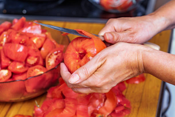 istock Hands removing the peel from the red tomato 1466323440