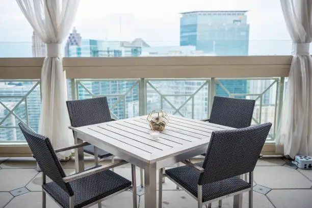 A horizon shot of a white table with four chairs in balcony Captured at the Peachtree Club in Atlanta, GA