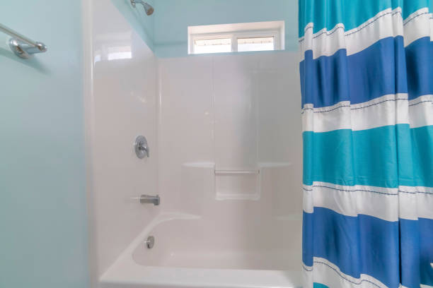 istock Image of a white bathroom with blue and white striped shower curtains. 1466325883