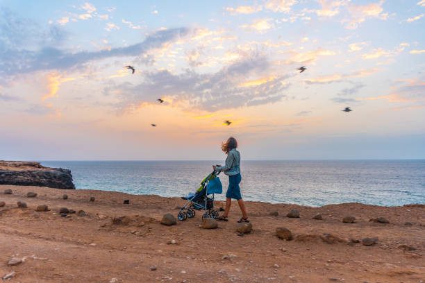 mère avec son fils marchant sur le littoral de la ville el cotillo au coucher du soleil, espagne - cotillo fuerteventura spain tourism photos et images de collection