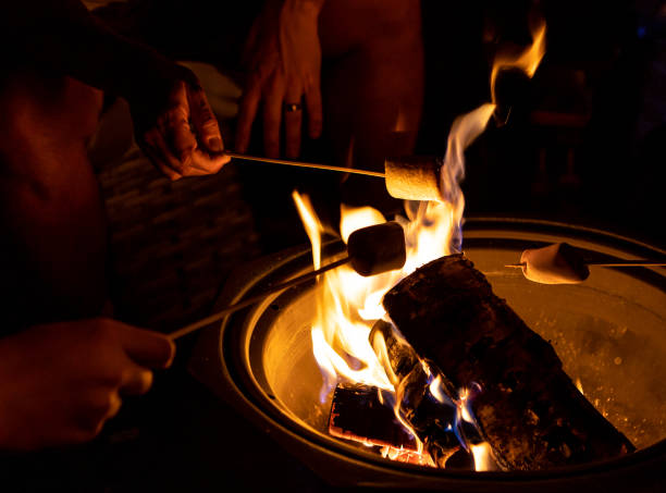 istock Closeup shot of people roasting marshmallows over a bonfire 1466332767