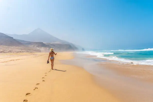 A woman on the Roque Del Moro in Cofete beach, Jandia natural park, Barlovento, south of Fuerteventura, Canary Island, Spain