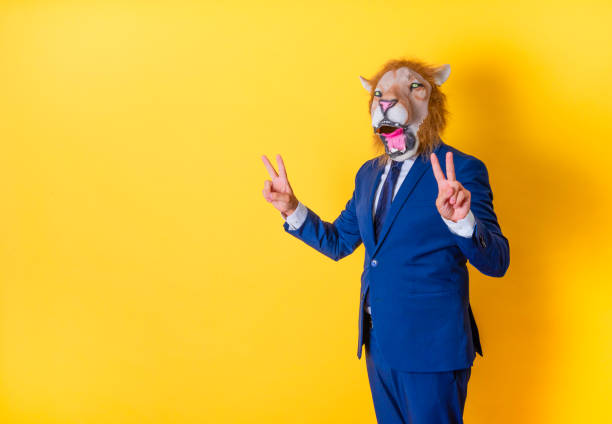 istock Businessman in lion mask making a victory gesture with both hands. 1466335946