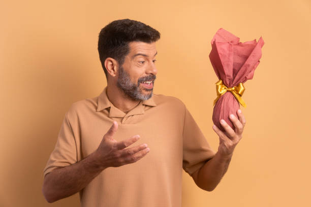 istock joyful brazilian man showing easter egg in studio shot. holiday, easter, celebration concept. 1466336467