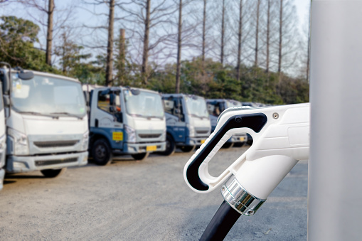 Close up of electric plug on car charging equipment, electric van being charged, electric car charging concept