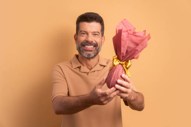istock happy mature man with easter egg in studio shot. holiday, easter, celebration concept. 1466336509
