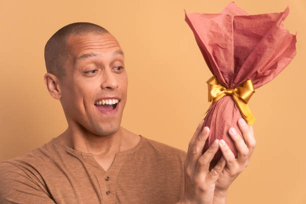 istock excited bald man with easter egg in beige background. holiday, easter, celebration concept. 1466336529