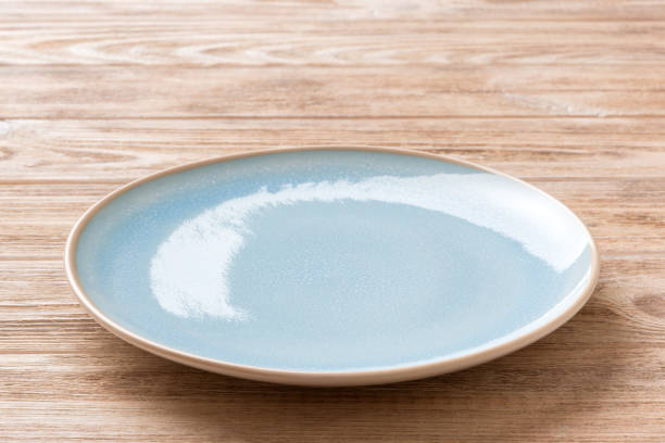 istock Perspective view of empty blue plate on wooden background. Empty space for your design 1466343150