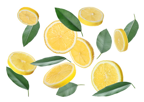 Fresh ripe lemon slices and green leaves flying on white background