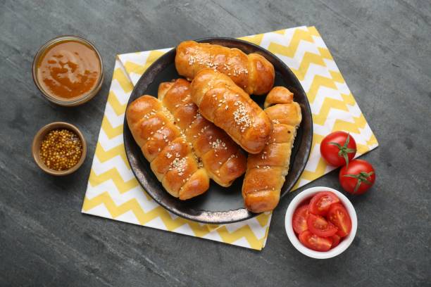 istock Delicious sausage rolls and ingredients on grey table, flat lay 1466351320