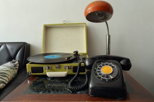 Black antique dial telephone and gramophone on table
