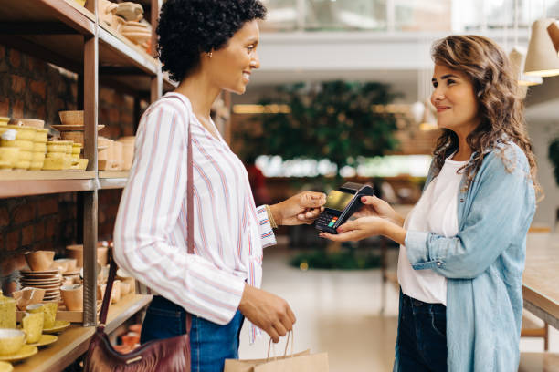 istock Ceramic store owner receiving a credit card payment from a customer 1466352223