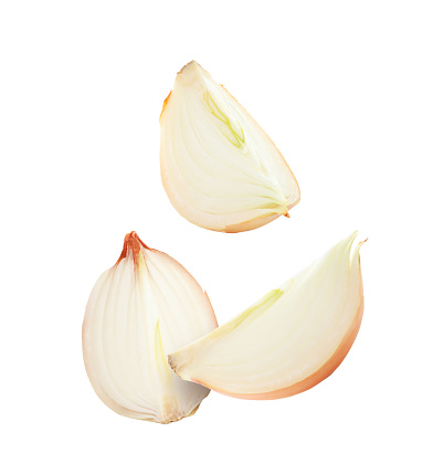 Fresh onion slices falling on white background