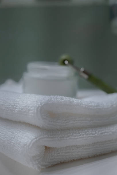 istock Stack of fresh towels and face roller on countertop in bathroom 1466354762