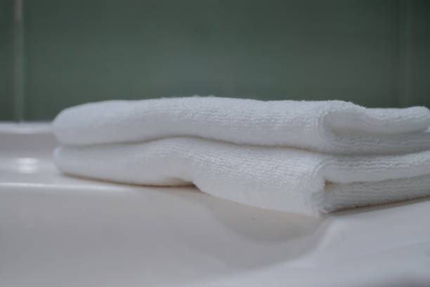 istock Stack of fresh towels and face roller on countertop in bathroom 1466354763