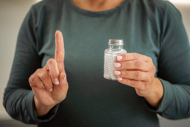 istock Woman holding salt shaker and gesturing with finger 1466356964